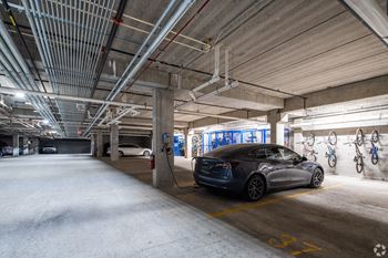 an electric car plugged into a charging station in a parking garage